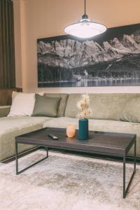 a living room with a couch and a coffee table at LIVALPIN ToGether in Garmisch-Partenkirchen +31 photos