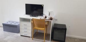 a desk with a television and a chair in a room at B&b BorgoVenezia in Scorzè