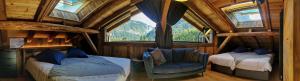 a bedroom with two beds and a chair in a room with windows at Le PasSionNant in Morzine