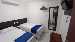 a hotel room with two beds and a mirror at Casa da Lalá in Fortaleza