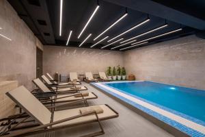 una sala con piscina e sedie di Bristol Hotel and Spa Bakuriani a Bakuriani