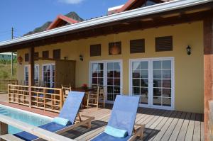 a house with a pool and two deck chairs at Kaye Coco in Soufri&egrave;re