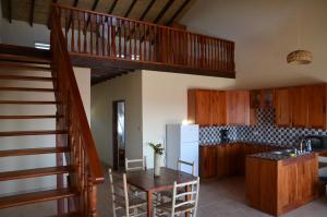 uma cozinha com uma escada, uma mesa e um frigorífico em Kaye Coco em Soufrière