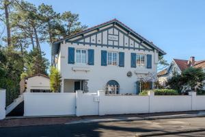 a white house with a white fence at Dépendance Villa Souleillous in Capbreton