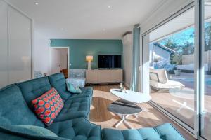 a living room with a blue couch and a table at Dépendance Villa Souleillous in Capbreton