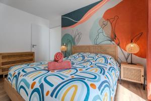 a bedroom with a bed with a painting on the wall at Dépendance Villa Souleillous in Capbreton +24 photos