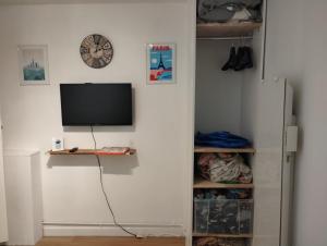 a room with a tv and a wall at Chambre chez l'habitant à Paris centre in Paris +4 photos