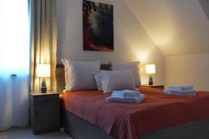 ミエルクレア・チュクにあるOrgona Apartmentsのタオルが敷かれたベッドのある寝室