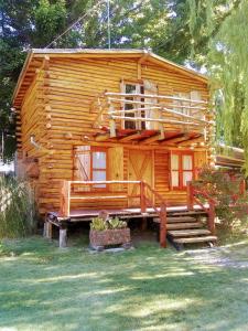 una baita di tronchi con portico e scale di fronte ad essa di Cabañas Walwalün a Tunuyán