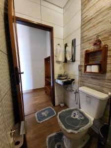 a bathroom with a toilet and a sink in it at Pousada Brisa das Dunas in Paulino Neves