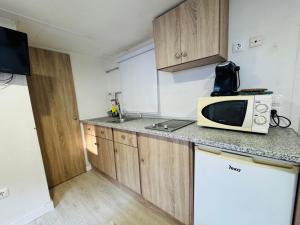 a small kitchen with a microwave and a counter at Bungalows Rurales Incluida Piscina 2 Columnas in Córdoba