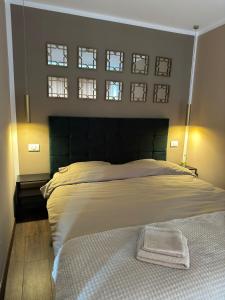a bedroom with a large bed with two windows at Cozy Nest Rasnov in Râşnov