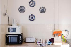 a kitchen with a microwave and plates on the wall at White Sun Hostel in Lagos
