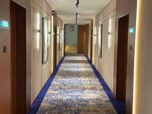 a hallway of a hotel with a carpeted corridor at Nelover Hafar-Serviced apartments in Hafr Al Baten