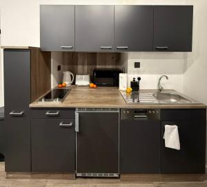 a kitchen with black cabinets and a sink at Iconic Suites Valletta in Valletta
