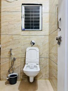 un bagno con wc e finestra di Chhatrachhaya Bhakt Niwas a Tuljapur