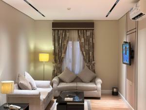 a living room with a couch and a tv at Nelover Hafar-Serviced apartments in Hafr Al Baten +23 photos