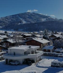 a snow covered city with houses and a mountain at Villa Juwel in Altenmarkt im Pongau