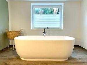 a white bath tub in a bathroom with a window at Wohlfühloase in Windeby