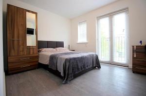ein Schlafzimmer mit Bett, Kommode und Fenstern in der Unterkunft Maricels hotel in Bedford