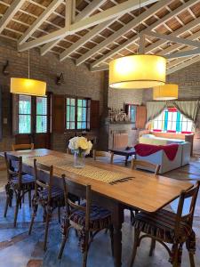 Un comedor con una gran mesa y sillas de madera. en Casitas El Lago, en Carhué