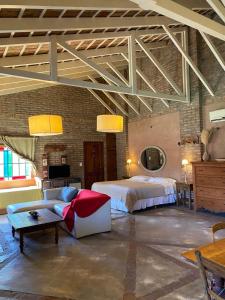 a large bedroom with a bed and a couch at Casitas El Lago in Carhué