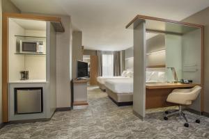 a hotel room with a bed and a desk and a television at SpringHill Suites Louisville Downtown in Louisville