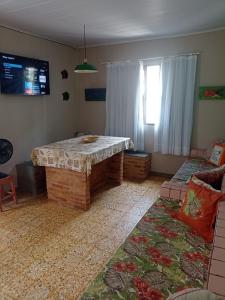 a living room with a table and a couch at Casa Centro pertinho da praia in Piúma