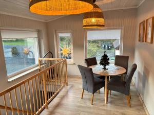 a dining room with a table and chairs and windows at Agroturystyka pod lasem in Brzeźnica