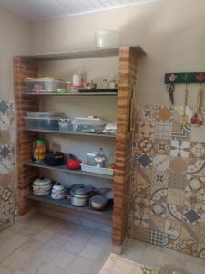 a kitchen with shelves filled with pots and pans at Casa Centro pertinho da praia in Piúma +14 photos