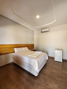 a bedroom with a large white bed in a room at Pousada Brisa das Dunas in Paulino Neves
