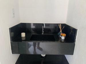 a kitchen counter with a sink and a faucet at Flat com Jacuzzi em Capitólio - Cantinho do Lago 1 in Capitólio +8 photos