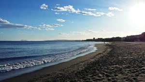 a sandy beach with the ocean and the sky at Apartamentos Turísticos Casa de La Borrega in Estepona