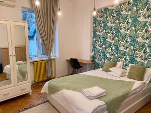 a bedroom with a bed with a green and white wallpaper at CoolKUSH 2U in Bucharest