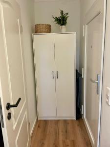 a white cabinet in a room with a door at Meerliebe in Cuxhaven