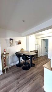 a dining room with a table and a kitchen at Le plein centre in Montbrison