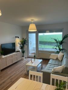 a living room with a couch and a tv at Meerliebe in Cuxhaven +17 photos