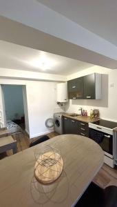 a kitchen with a wooden table in a room at Le plein centre in Montbrison