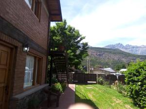 a brick house with a staircase next to a window at Acacias in El Bolsón