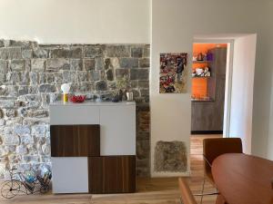a living room with a stone wall and a counter at Appartamento Betta in Borgo in Gorizia +15 photos