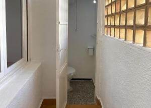 a white bathroom with a toilet and a window at Disfruta frente al mar, a 50 metros, y desconecta in Torre de la Horadada +10 photos