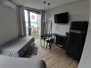 a bedroom with a bed and a desk and a television at Casamar paraíso na praia com a vista do mar dos sonhos piscina e spa in Guarujá