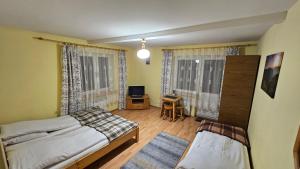 Un dormitorio con dos camas y un escritorio. en Willa Pod Kopiencem, en Zakopane