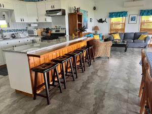 a kitchen with a bar with stools at House of Blue at Turtle Cove Long Island Bahamas in Long Island