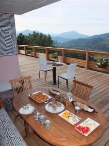 a table with plates of food on a deck at Katsoleil in La Bâtie-Neuve