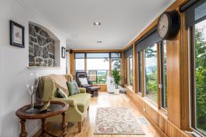 a living room with windows and a clock on the wall at Far Horizons Luxury Vacation Home in Montebello