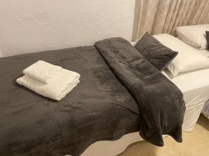 łóżko z czarnym kocem i poduszkami w obiekcie Apartamento Las Brisas w mieście Mijas +37 zdjęć