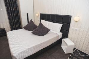 a bedroom with a bed with a black headboard and pillows at Deko Rome in Rome