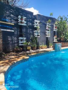 ein Swimmingpool vor einem Haus mit blauem Wasser in der Unterkunft Habitación con baño para 4 personas para los dias 21 y 22 in Corrientes