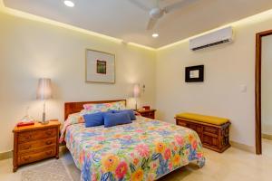 a bedroom with a bed with blue pillows on it at El Tigre Resort, Quinta San Miguel in Nuevo Vallarta  +38 photos